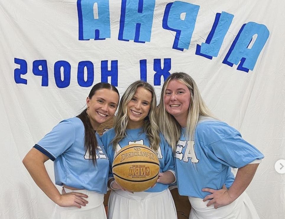 Alpha Xi Hoops sorority holding basketball / 